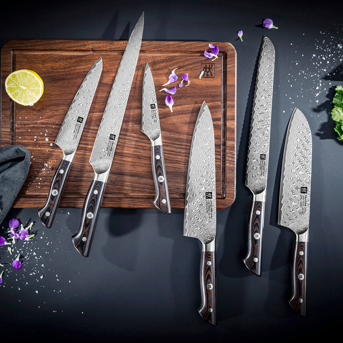 Eksklusive Zwilling kokkeknive i damaskusstål på skærebræt – professionelt køkkenudstyr til madlavning og gastronomi.