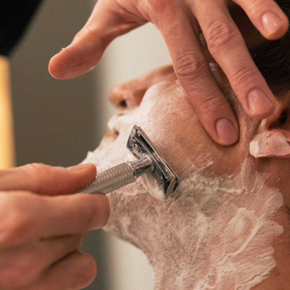 Mand der barberer sig med DE-Skraber og barberskum. Barbering uden irritation
